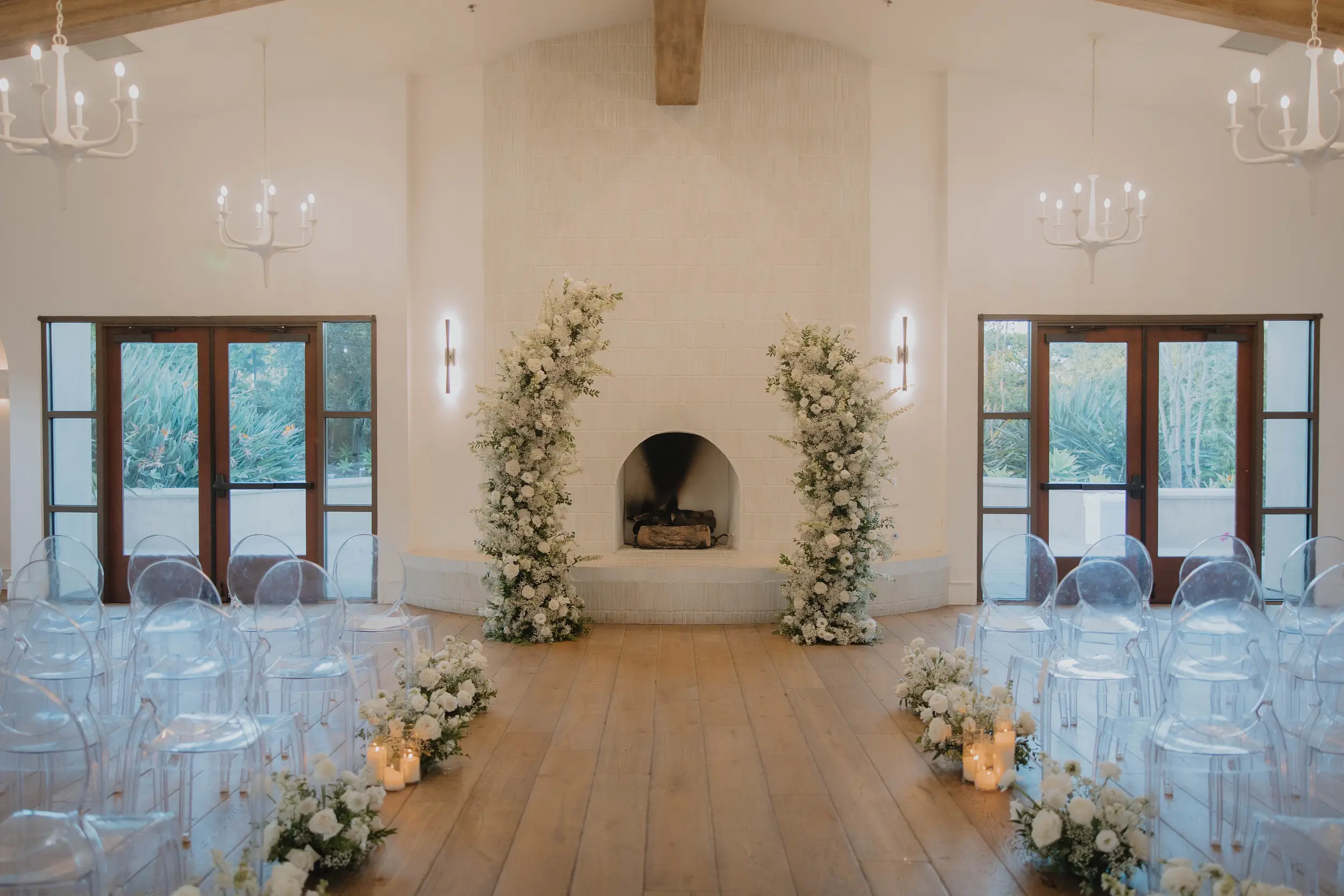 White floral wedding ceremony decor frames in an indoor fireplace backdrop.