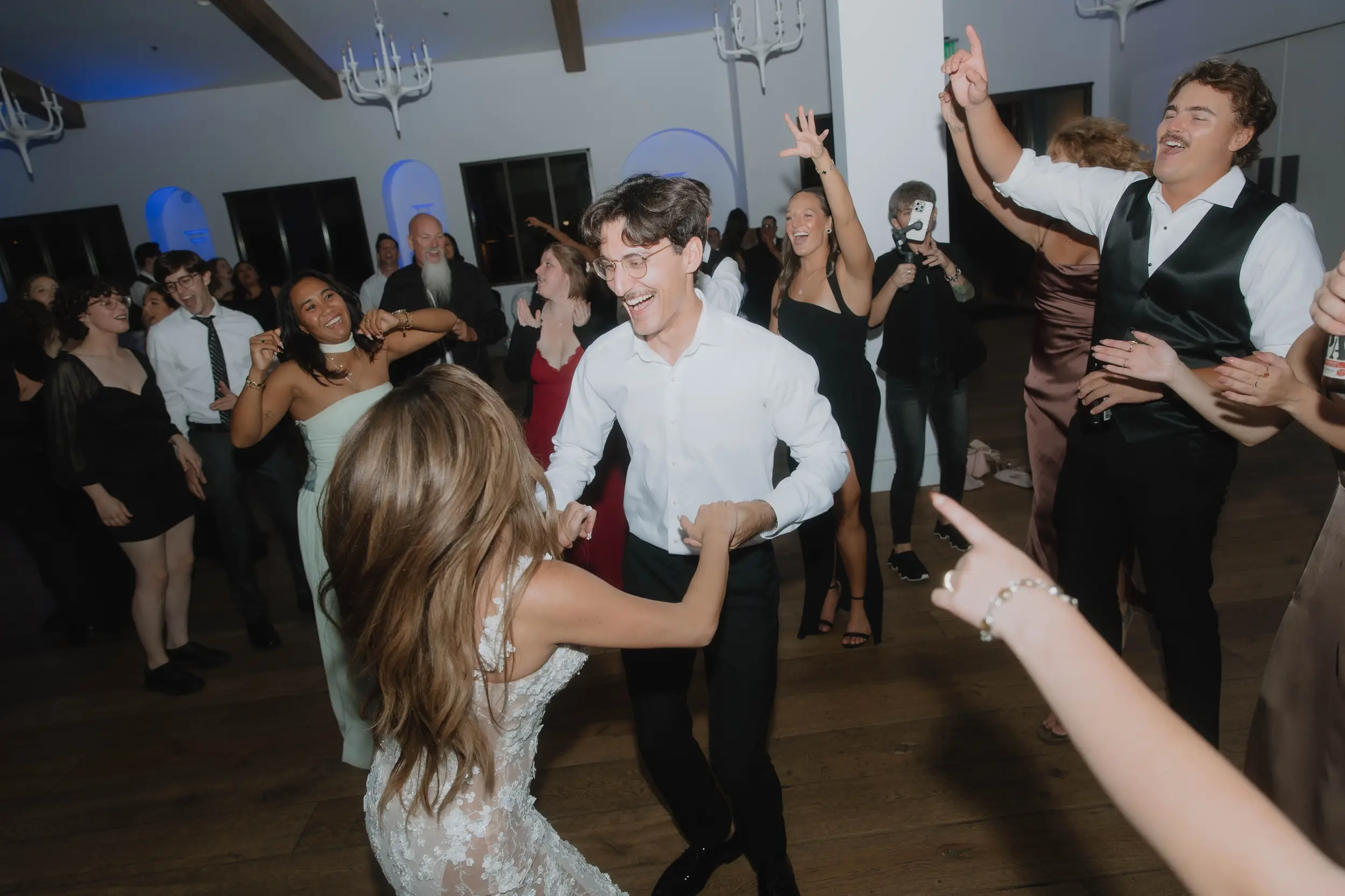 Bride, groom, and wedding party share last dance inside Serra Plaza wedding venue.