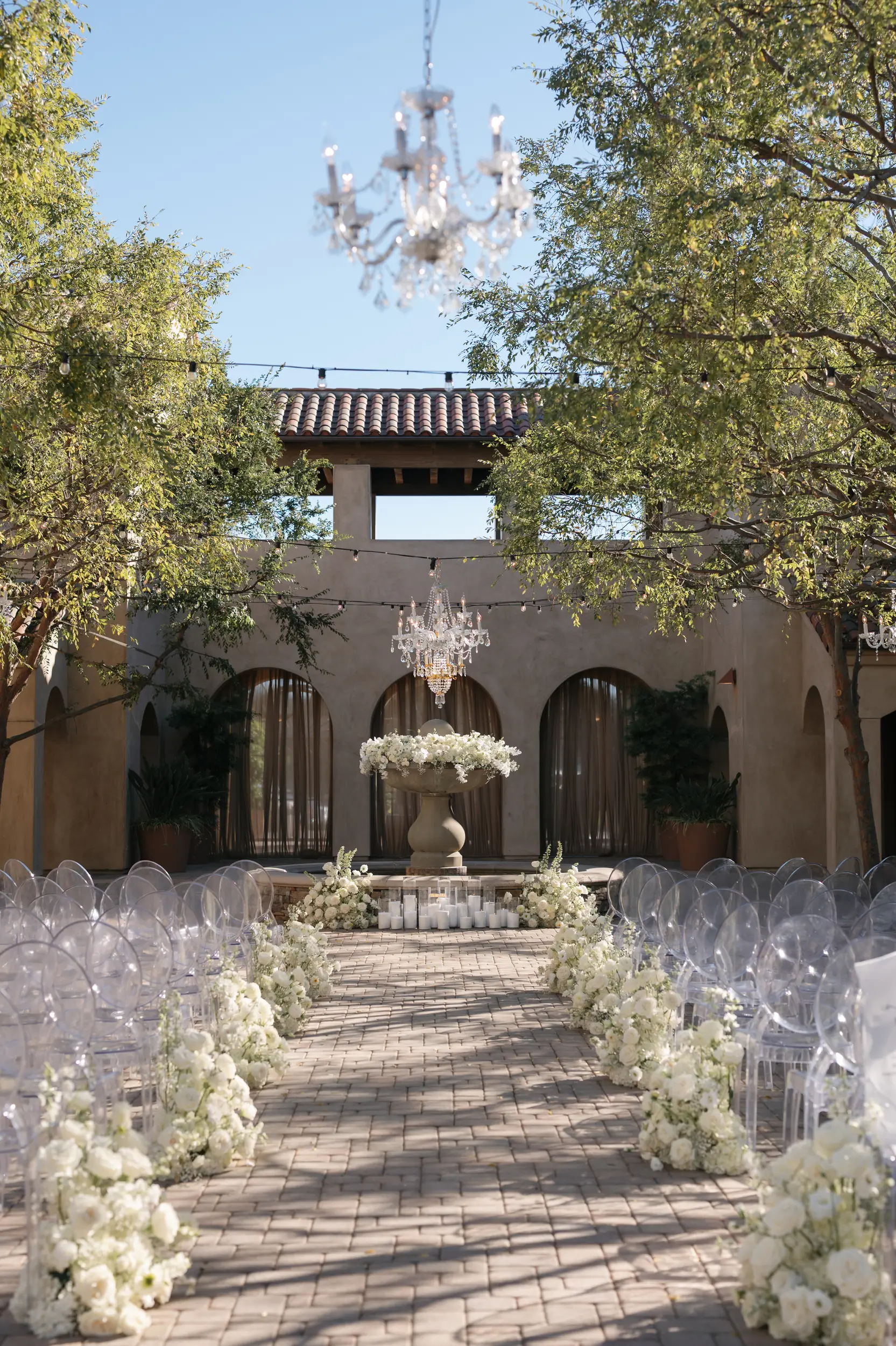 White rose floral arrangements line the aisle of Serra Plaza and decorate the Spanish fountain.