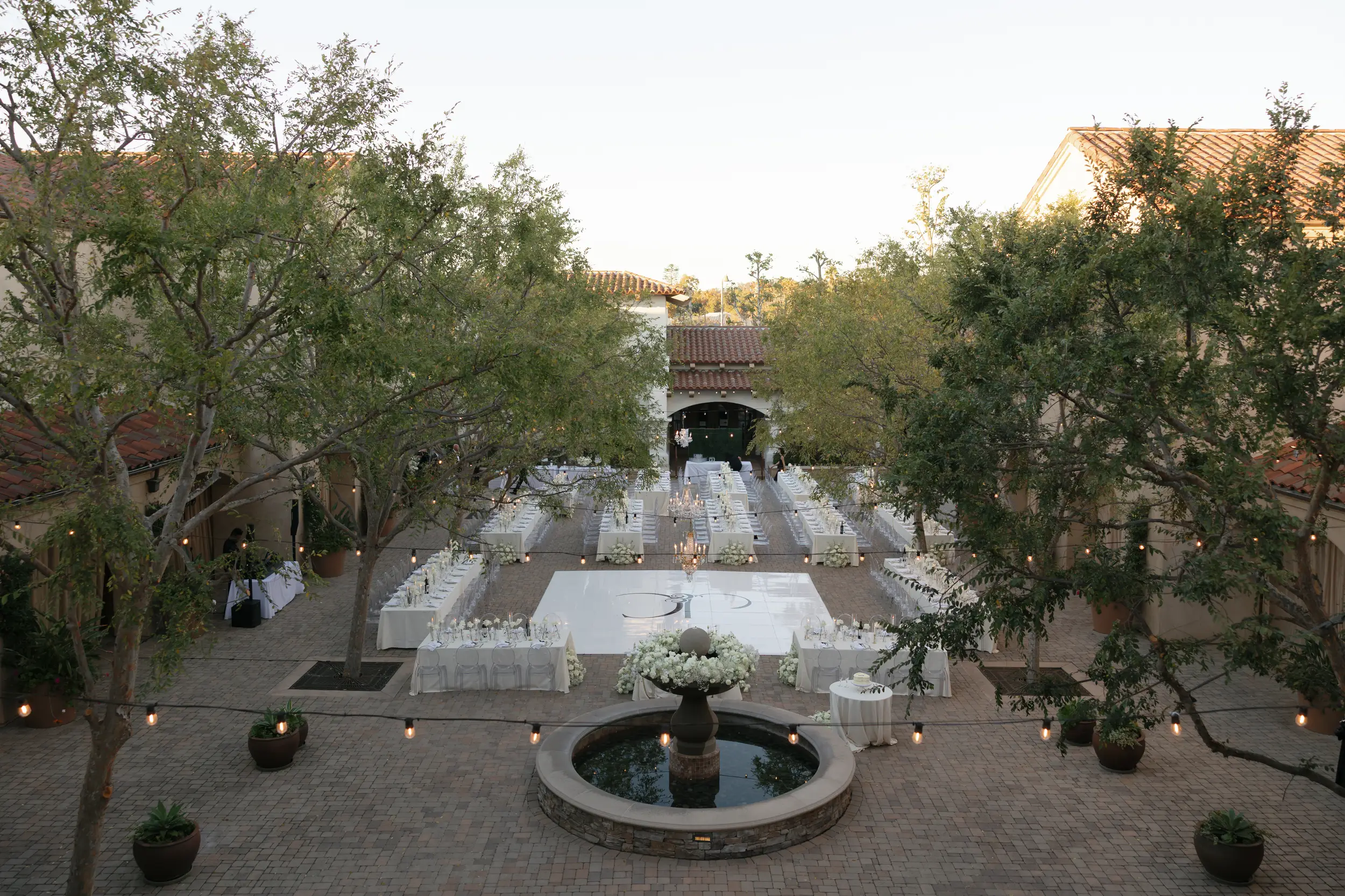 Birds-eye-view of the Serra Plaza Courtyard with white reception tables and a white dance floor.