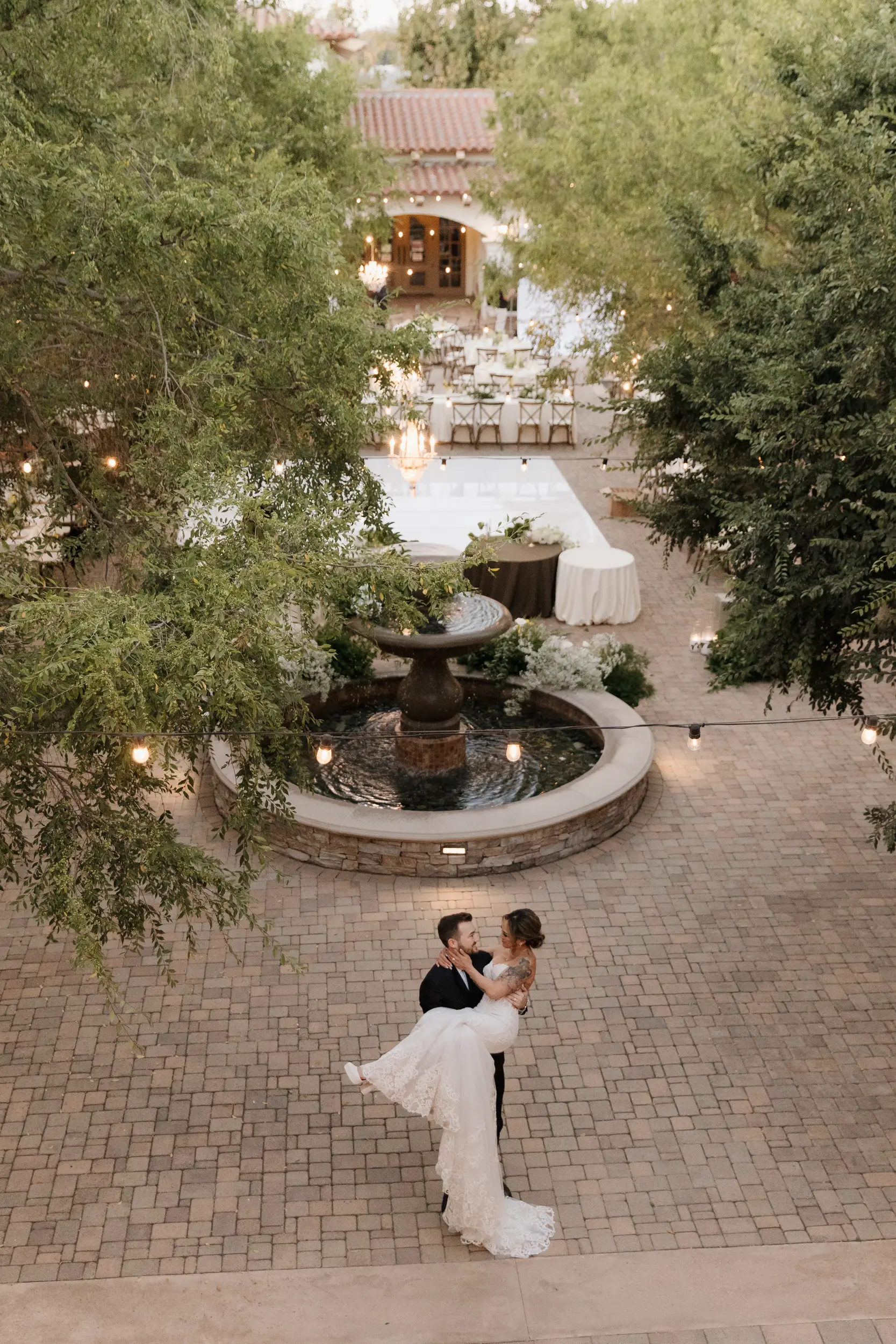 Bride and groom twirl with reception in the background.