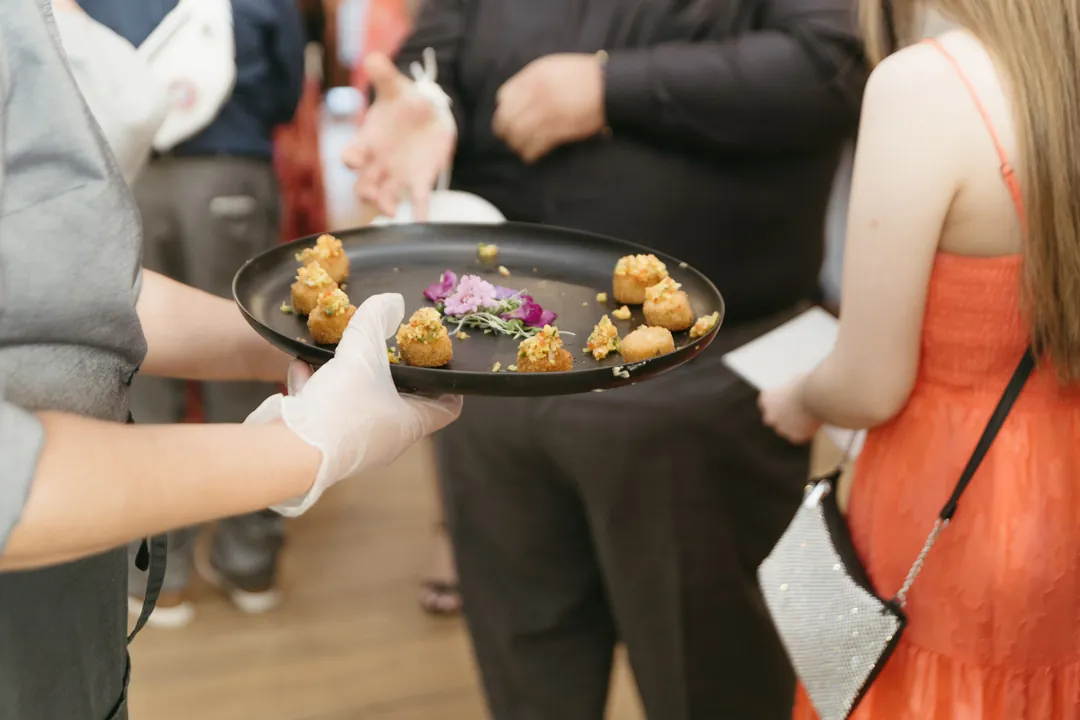 Catering team tray passes cocktail hour Crab Cake hors d'oeuvres.