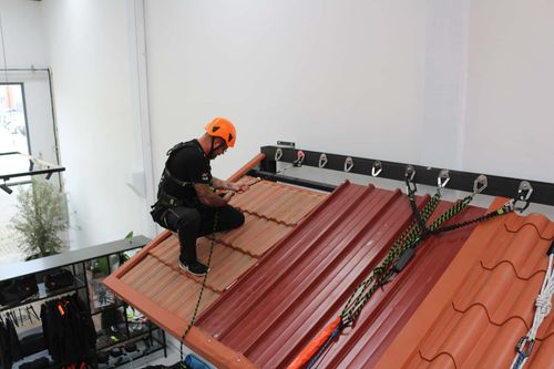 Person i Fall Safe fallskyddsutrustning på ett tak