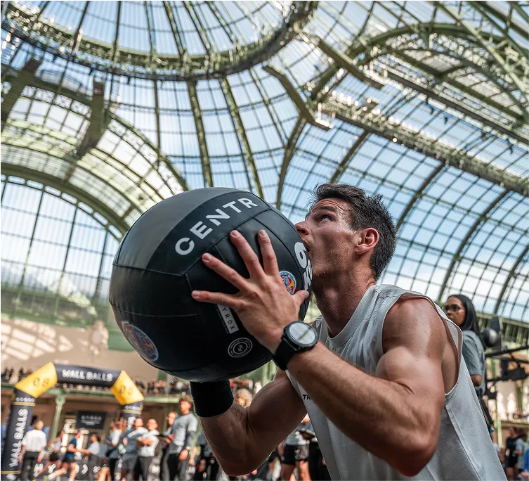 Athlète en pleins exercice de wallball Hyrox
