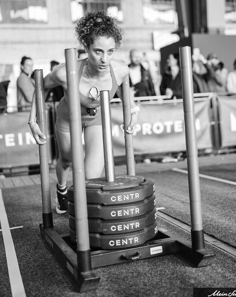 Ahtlète Trainsweateat Ambre Keram durant l'épreuve Hyrox de sled push.