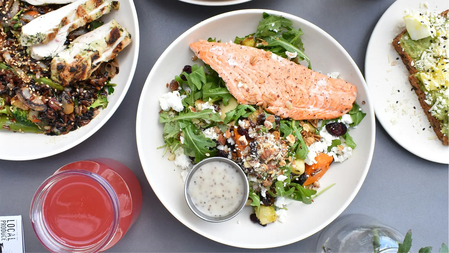 Table vue de dessus avec salade, poisson, poulet et légumes, pour illustrer combien de calories par jour manger
