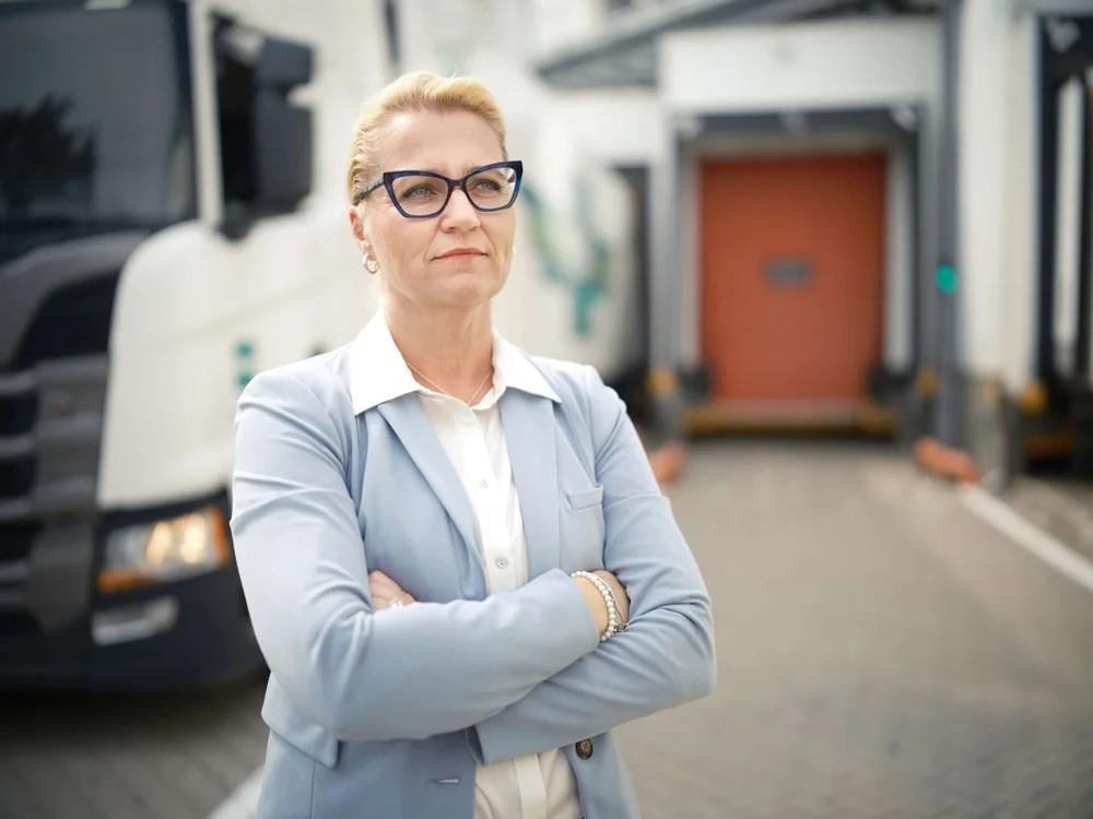 Man standing next to his van with crossed arms.