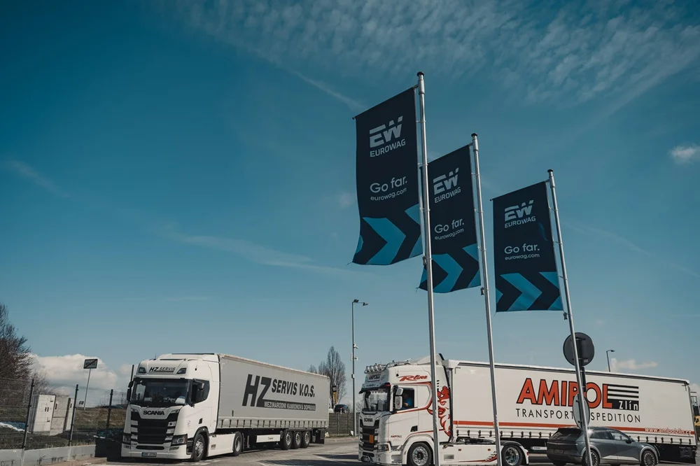 Two red trucks refueling at a Eurowag fuel station.