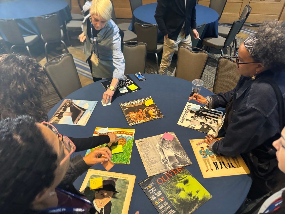 A team at a table covered with vinyl record sleeves