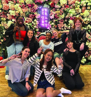 Group of interns posing in front of a flower wall during a social outing.