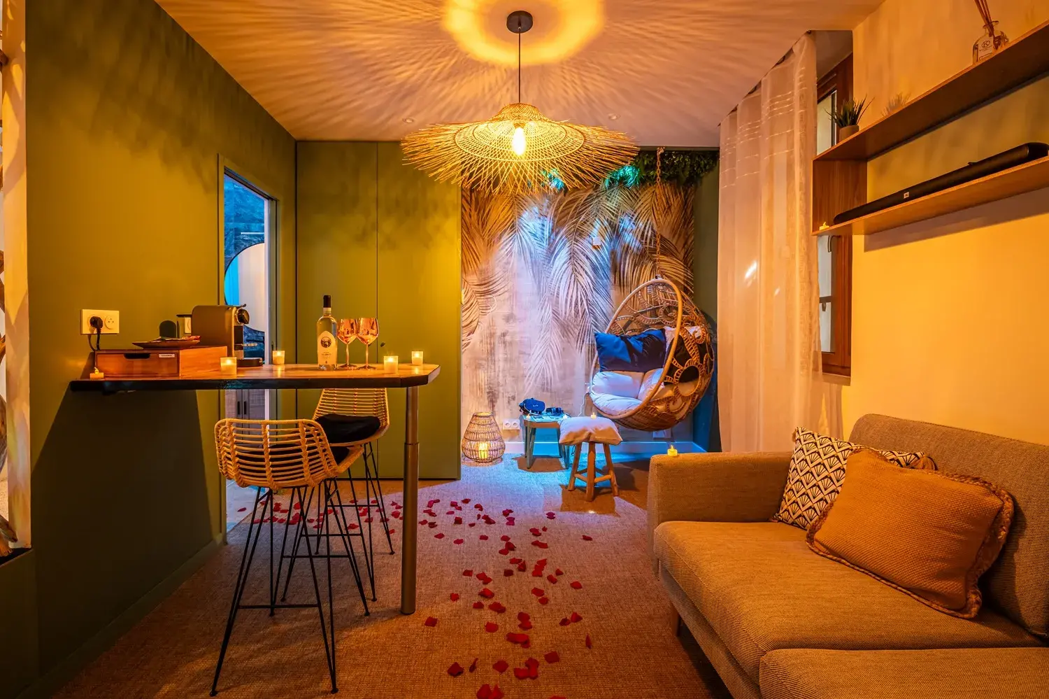 OIQIA’s Destination Bali apartment in Narbonne, styled with tropical décor, rose petals, soft lighting, and a cozy lounge area for a romantic couple’s stay.