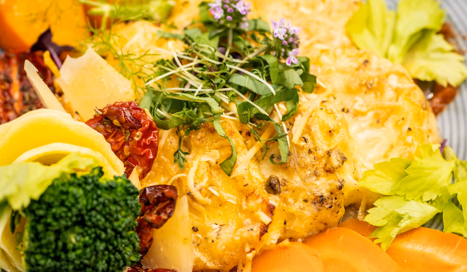 Käsiger Auflauf mit Brokkoli, getrockneten Tomaten und frischen Kräutern