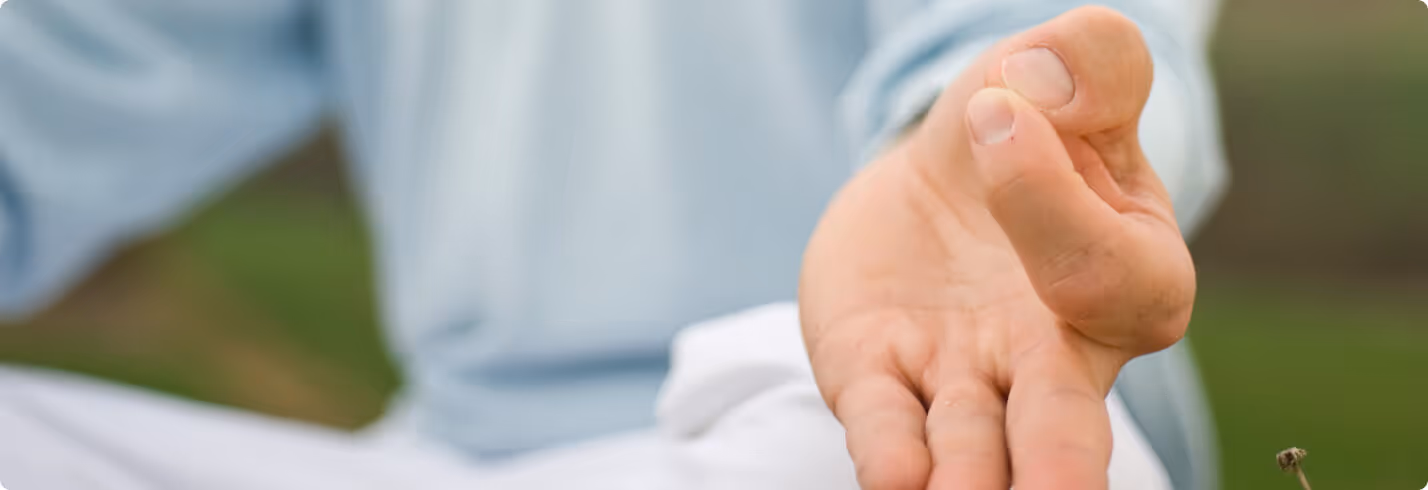 Close-up of a hand with blurry background in soft blue and green tones