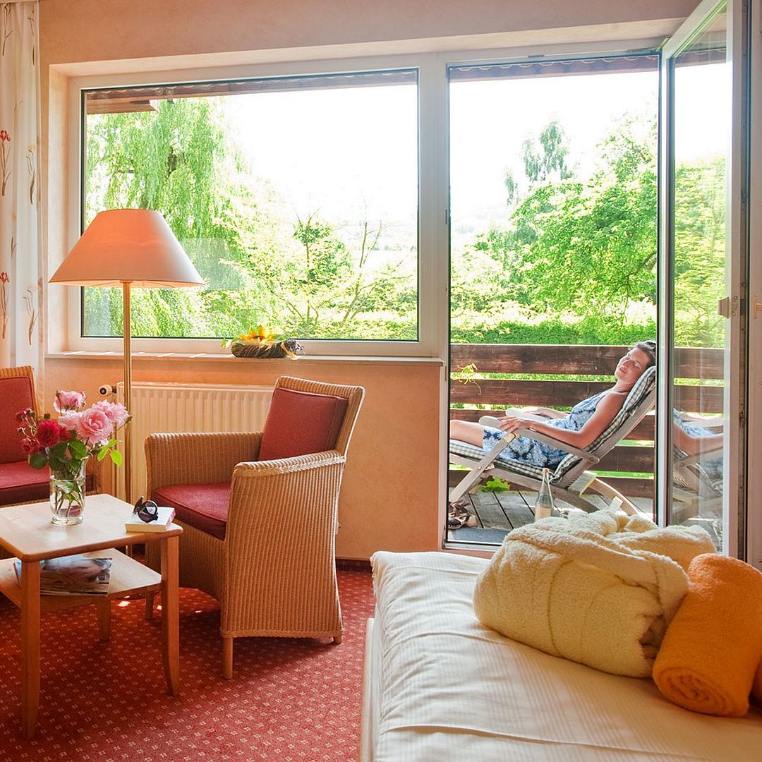 Gemütlicher Wohnraum mit Blick auf Garten und Terrasse im Sommer