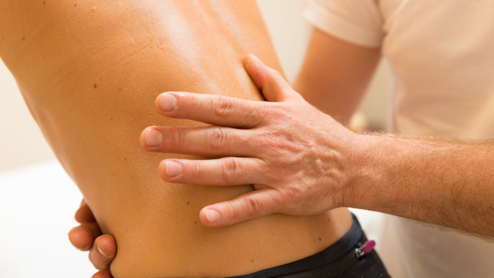 Medical professional examining patient's abdomen during health checkup
