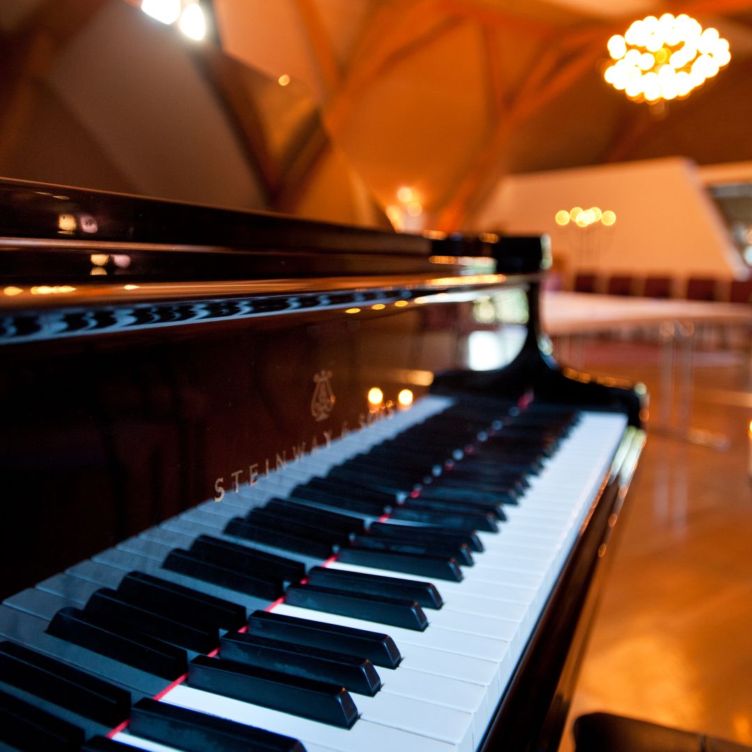 Steinway-Flügel mit warmen Lichtern und verschwommener Umgebung