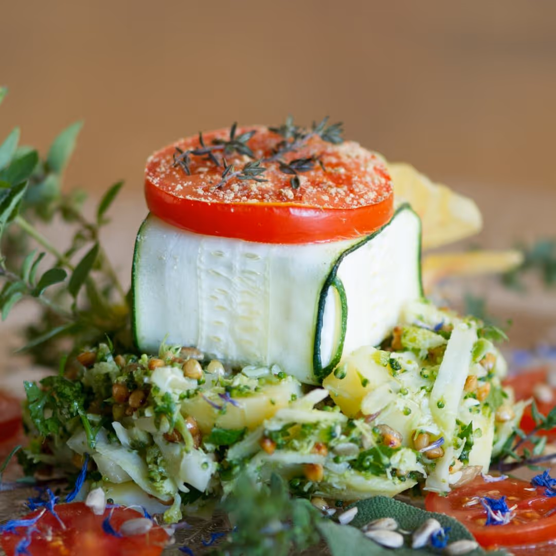 Gourmet-Salat mit Zucchini-Röllchen, Tomate und grüner Kräutervinaigrette
