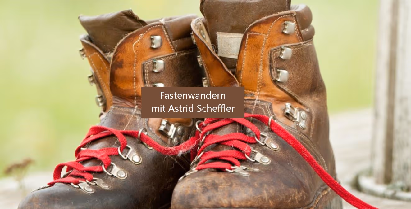 Alte Wanderschuhe mit roten Schnürsenkeln, bereit für eine Wanderung