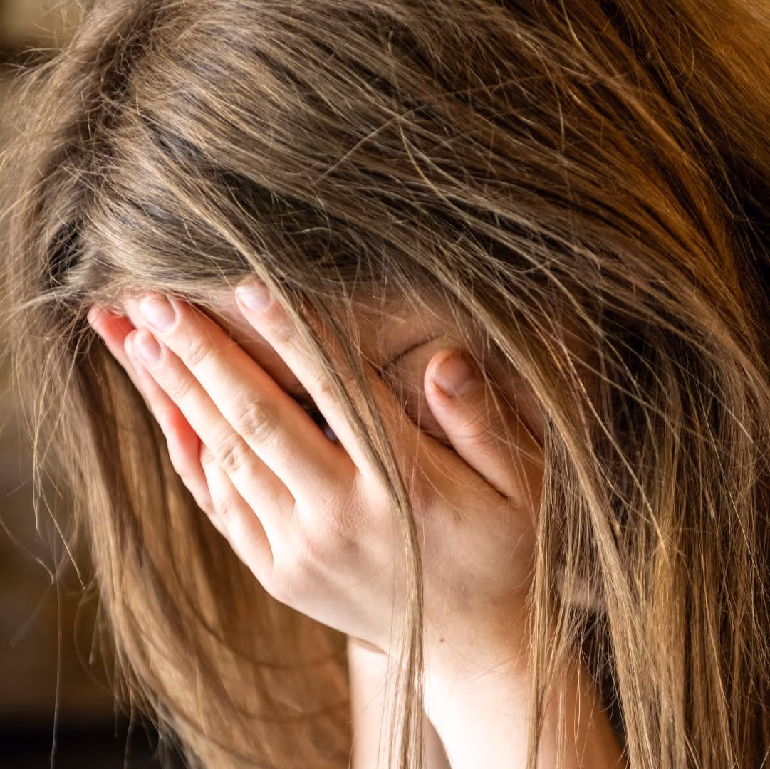 Frau mit Hand vor dem Gesicht, Emotionen von Traurigkeit oder Stress