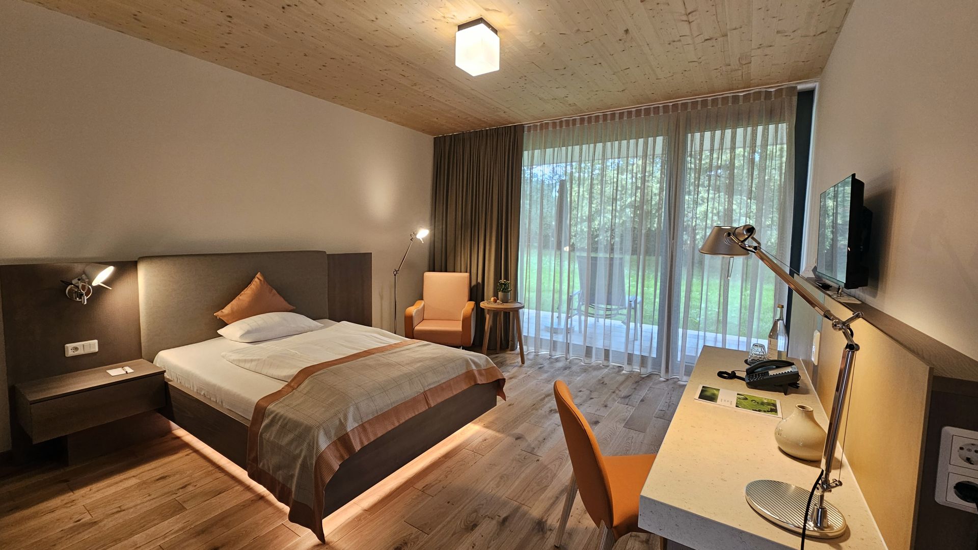 Hotelzimmer im Tannenhaus mit Holzboden, Einzelbett und Blick in den Park