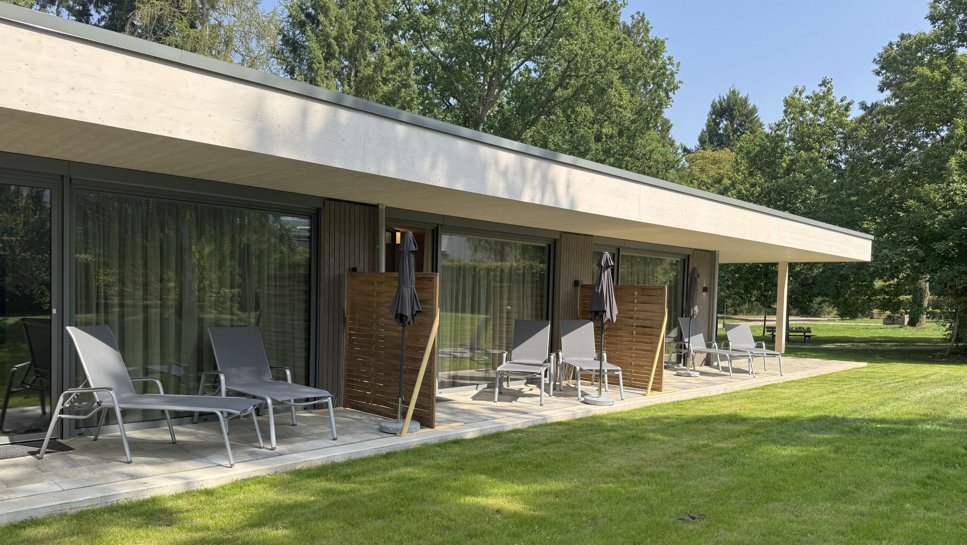 Tannenhaus mit Terrasse, Liegestühlen und direktem Zugang in den Park