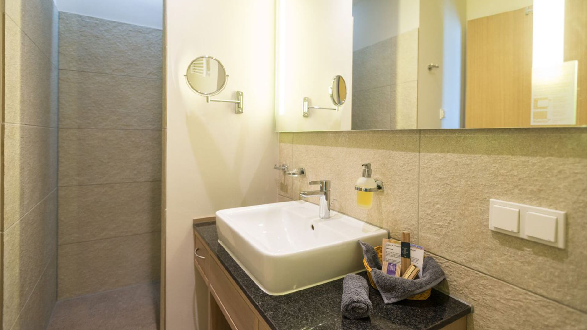 Badezimmer Haus Igelsberg mit Waschbecken, Spiegel und Handtüchern