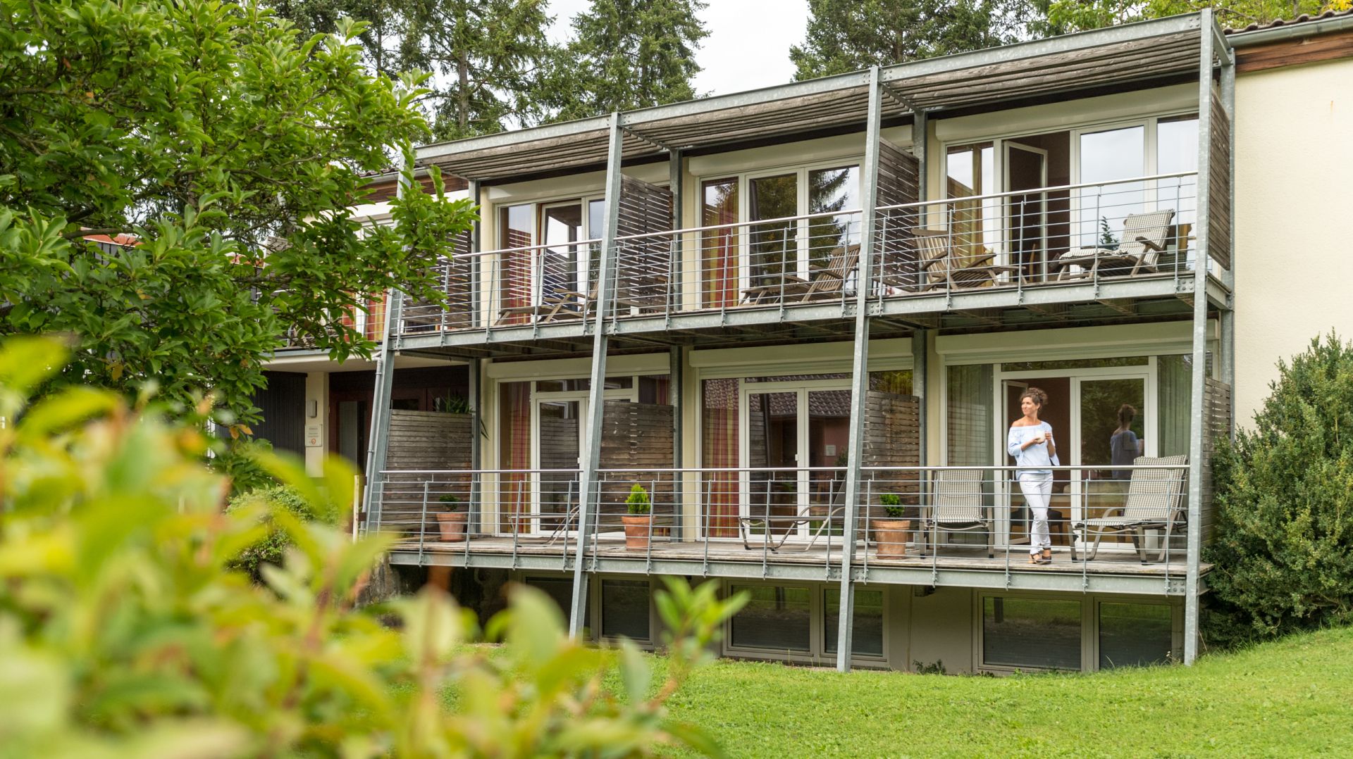 Südhaus mit üppigem Grün vor der Loggia oder dem Balkon