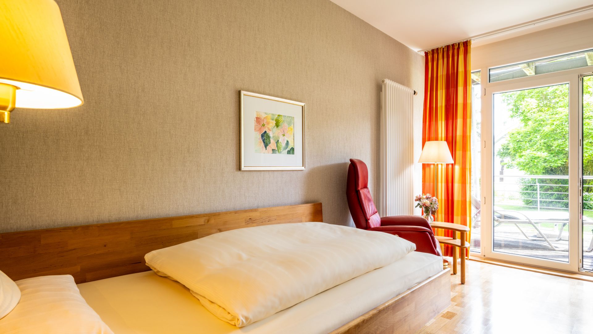 Gemütliches Einzelzimmer mit Holzbett und Blick ins Grüne