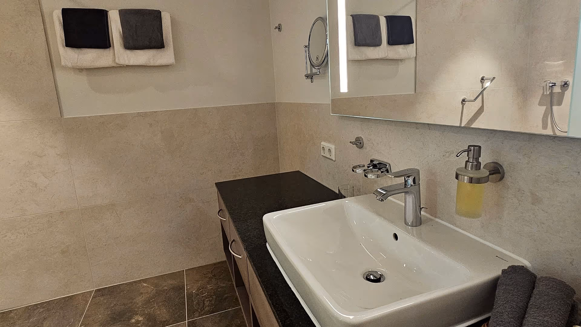 Badezimmer im Tannenhaus mit weißem Waschbecken und Spiegel - modern und barrierefrei