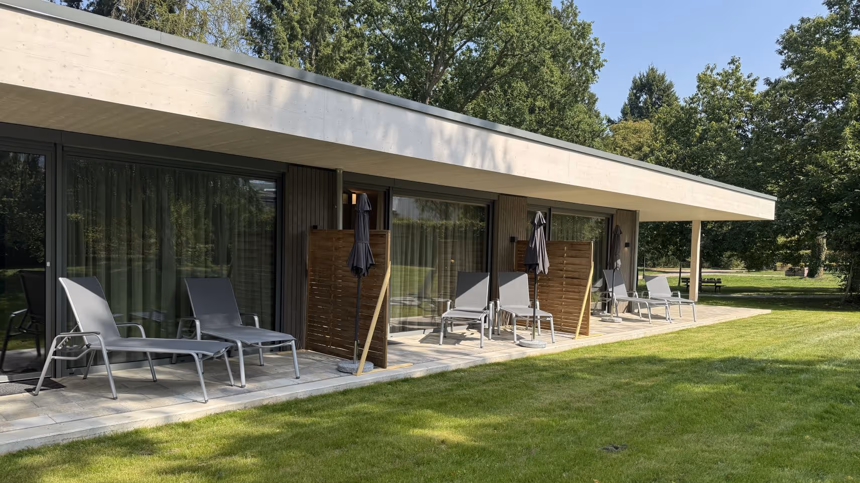 Menschels Tannenhaus mit Terrasse, Liegestühlen und grünem Garten