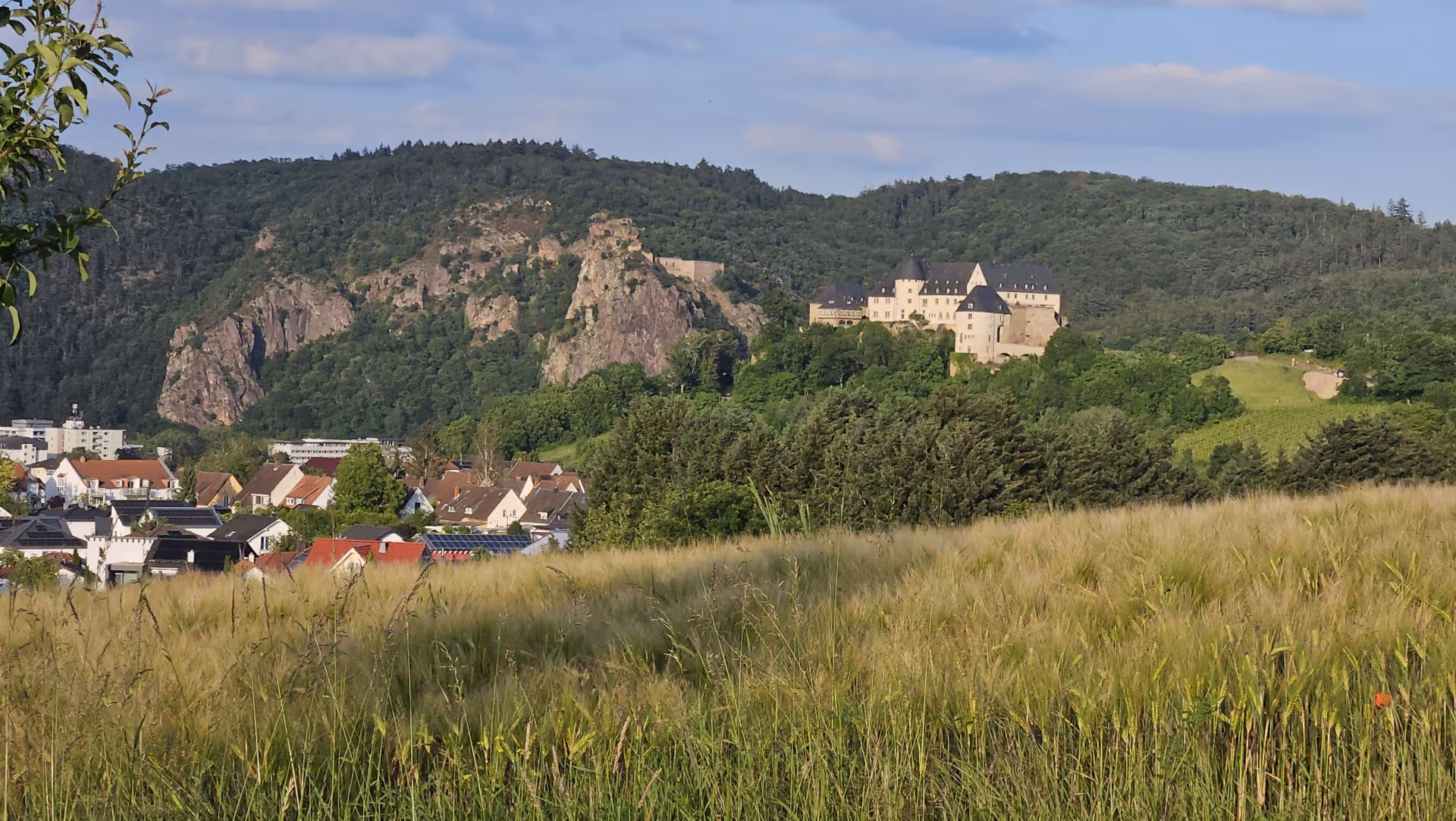 Medieval castle nestled among rocky hills and green fields in European countryside