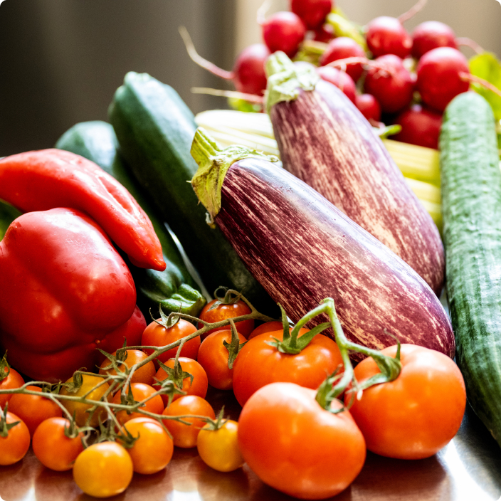 Frische Tomaten, Auberginen, Paprika und Radieschen auf Holzoberfläche