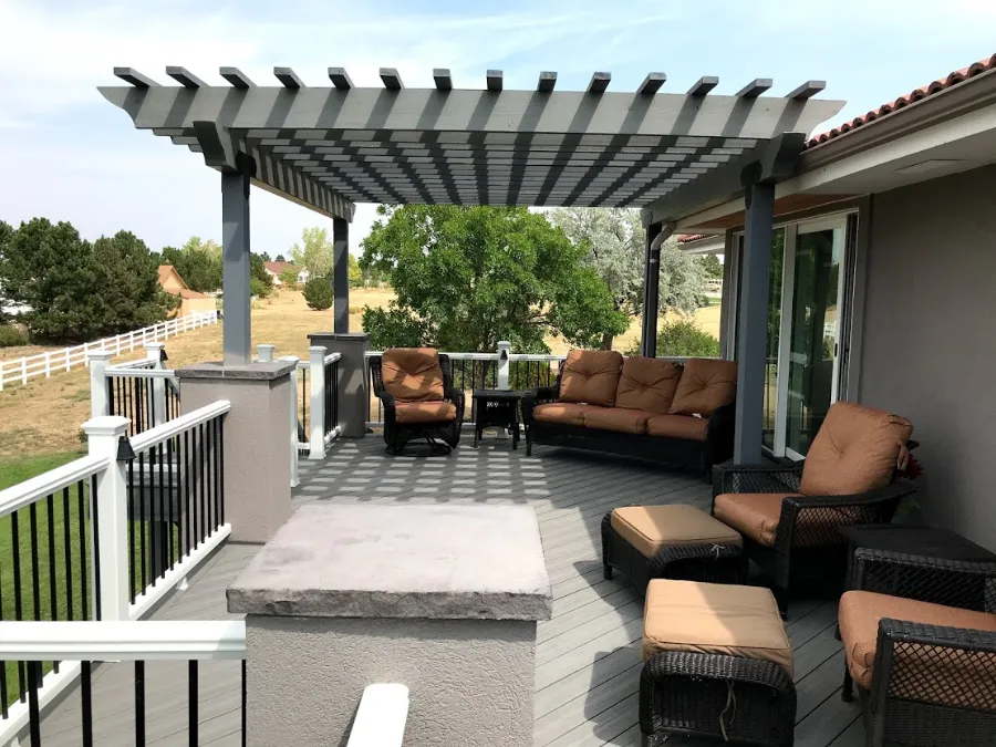 Covered deck with outdoor sofa seating and white railing overlooking an open yard