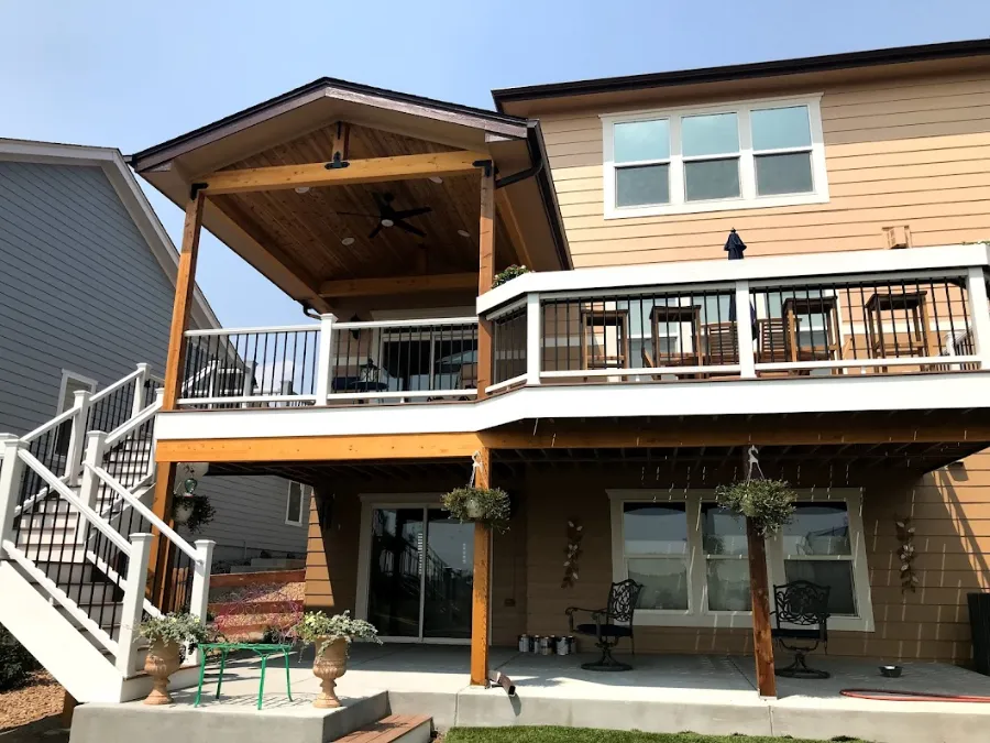 Two-story composite deck with white railings above a covered lower patio