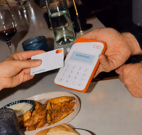 Cliente paga con tarjeta en una terminal Clip en un restaurante
