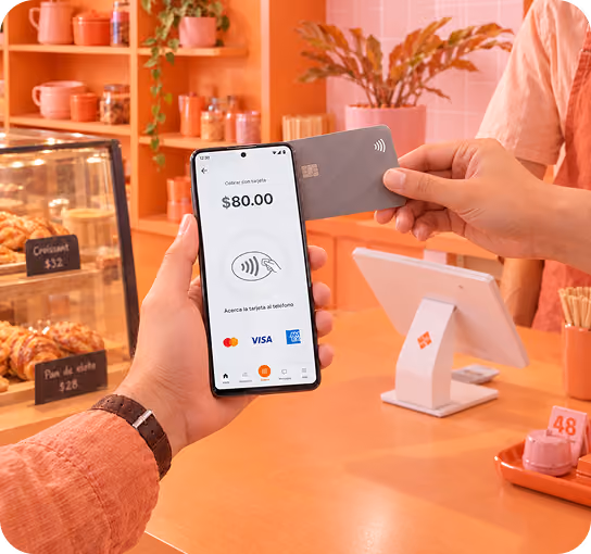 Cliente paga con tarjeta en un celular con Tap to Pay en una panadería