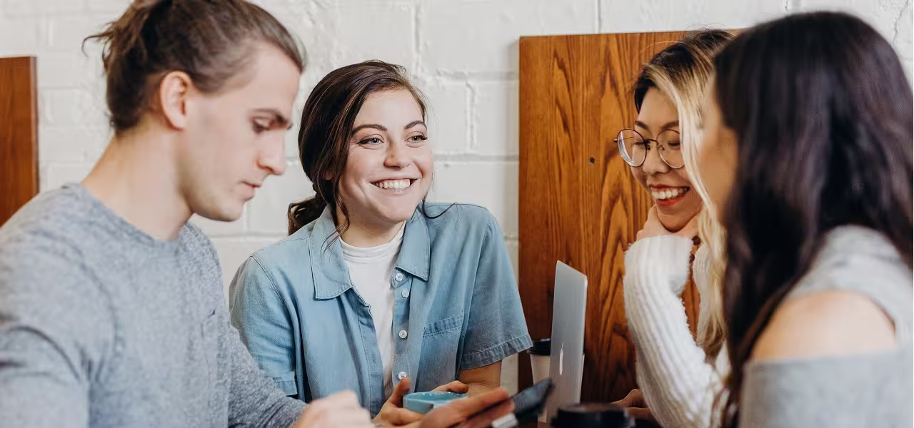 Group of young people in informal meeting smiling while planning telematic shareholder meetings