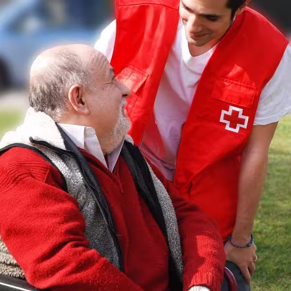 Spanish Red Cross volunteer accompanying an elderly person during his General Assembly.