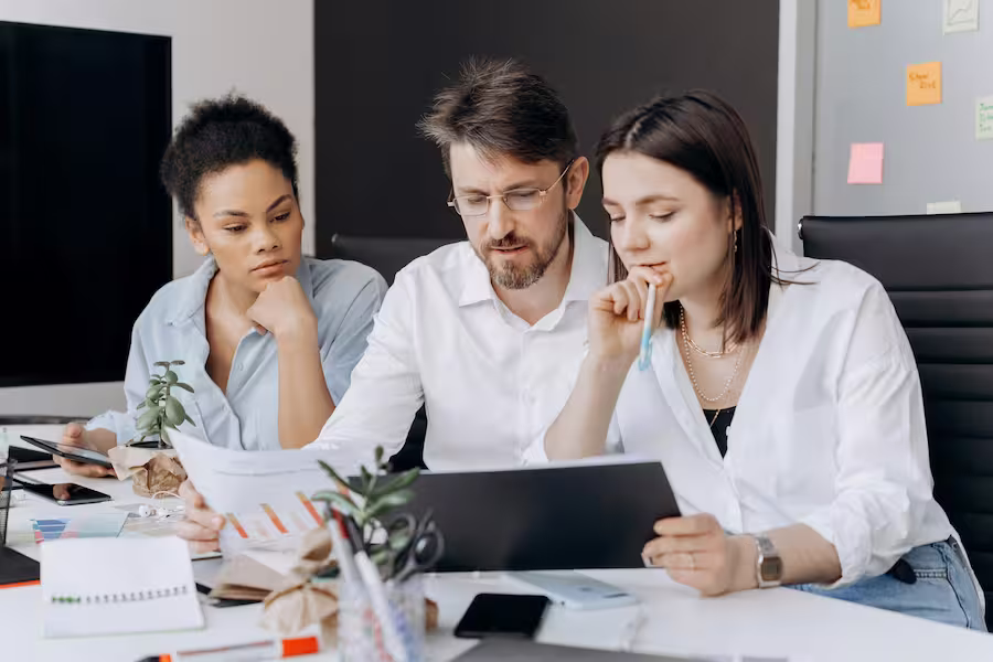 Diverse people in front of a computer, working in a relaxed and safe environment, transmitting trust and collaboration in the management of online voting or meetings.