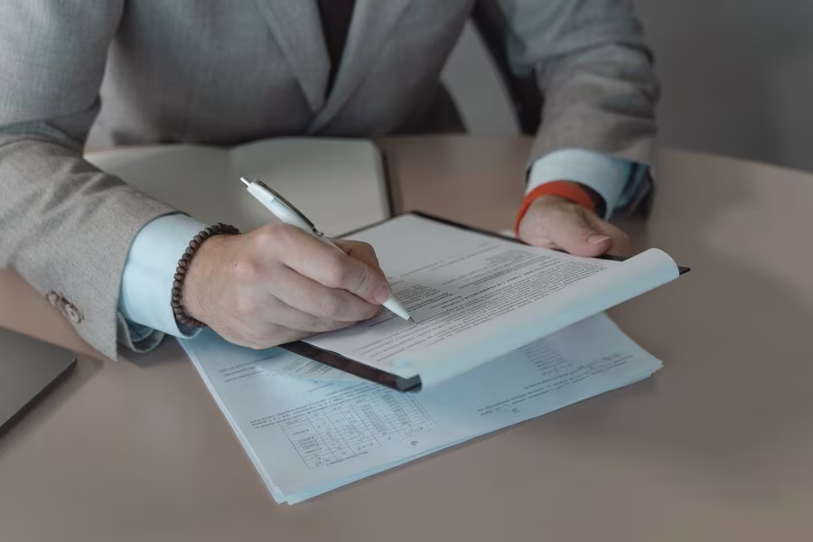 Persona redactando las instrucciones de voto en un documento impreso sobre un escritorio
