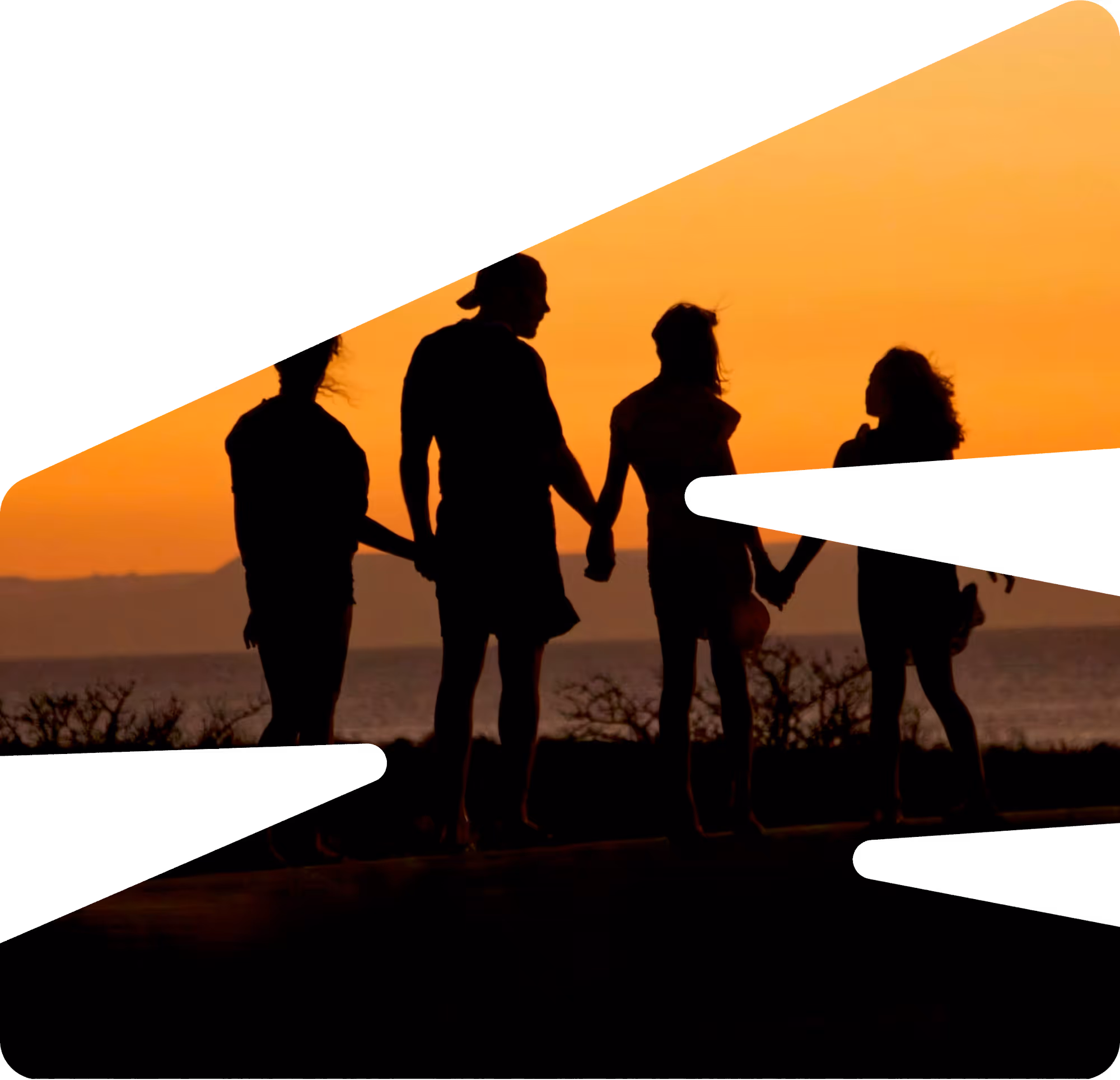 Family of four walking on a forest path covered with autumn leaves, with a child on the father's shoulders.