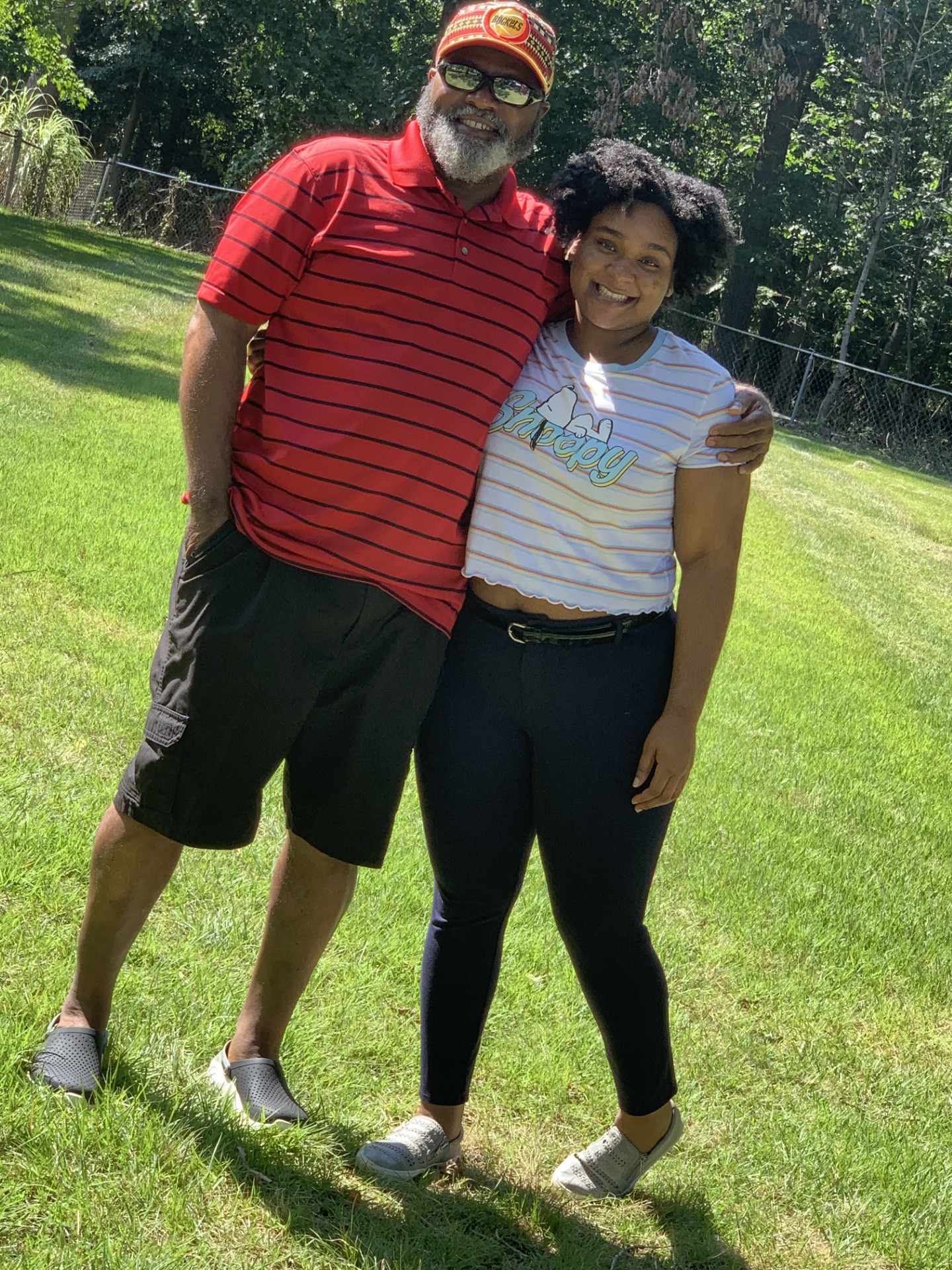 A father and daughter are hugging and posing for a picture