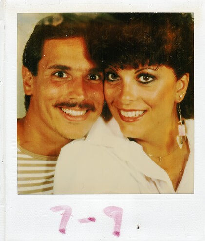 A Polaroid picture of a man and a woman smiling and hugging