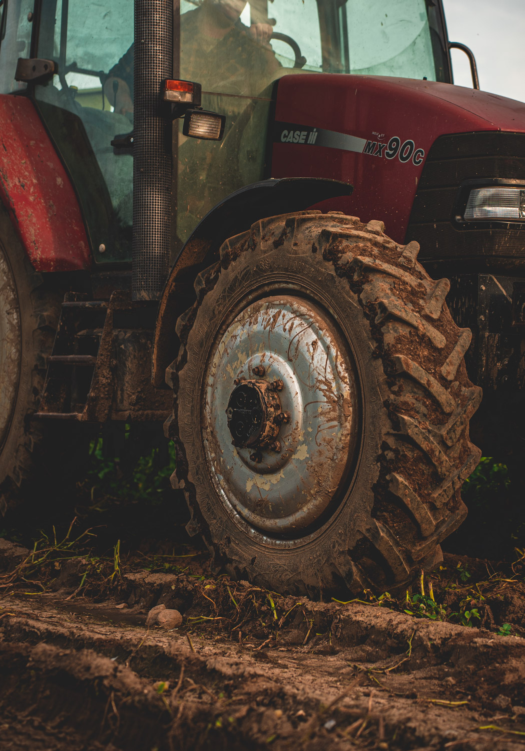 Ein roter Traktor der über ein Feld fährt.