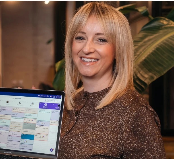 Sarah from Establishment 57 holding a laptop with Slick