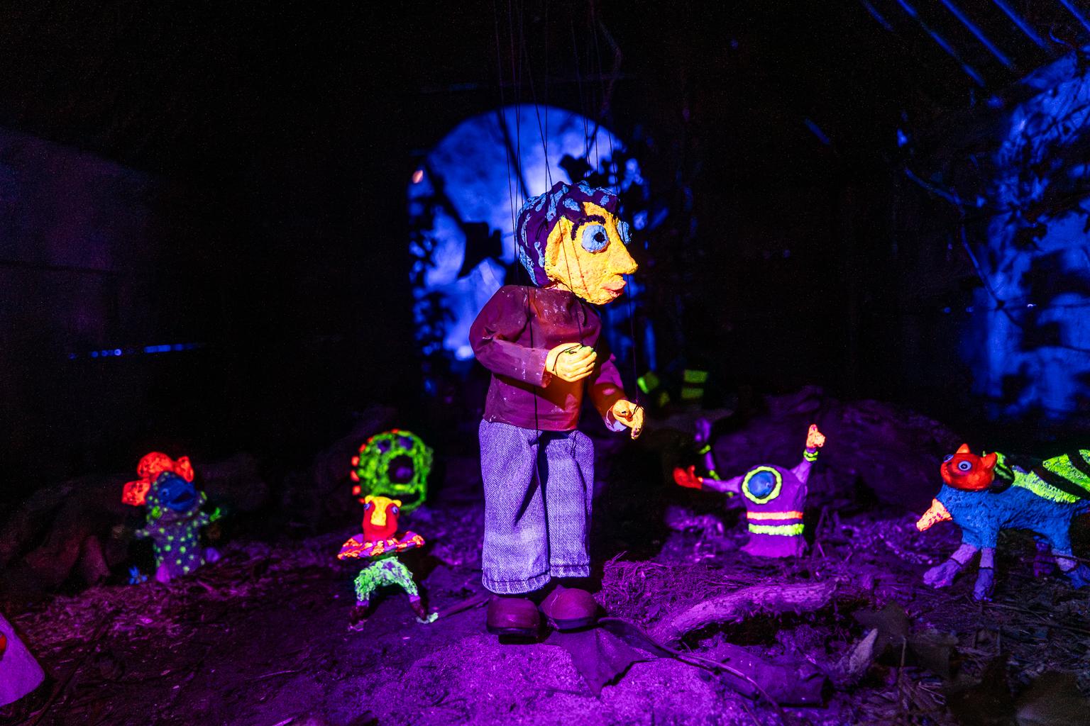 Jan Franssen op zijn knieën tijdens het maken van een muurschildering