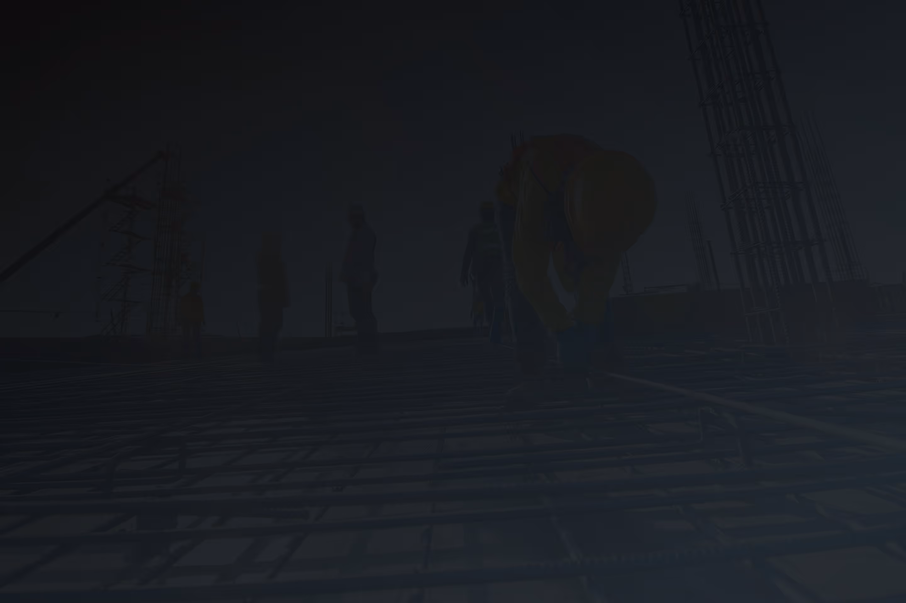 Construction workers installing steel rebar on a building site under clear sky.
