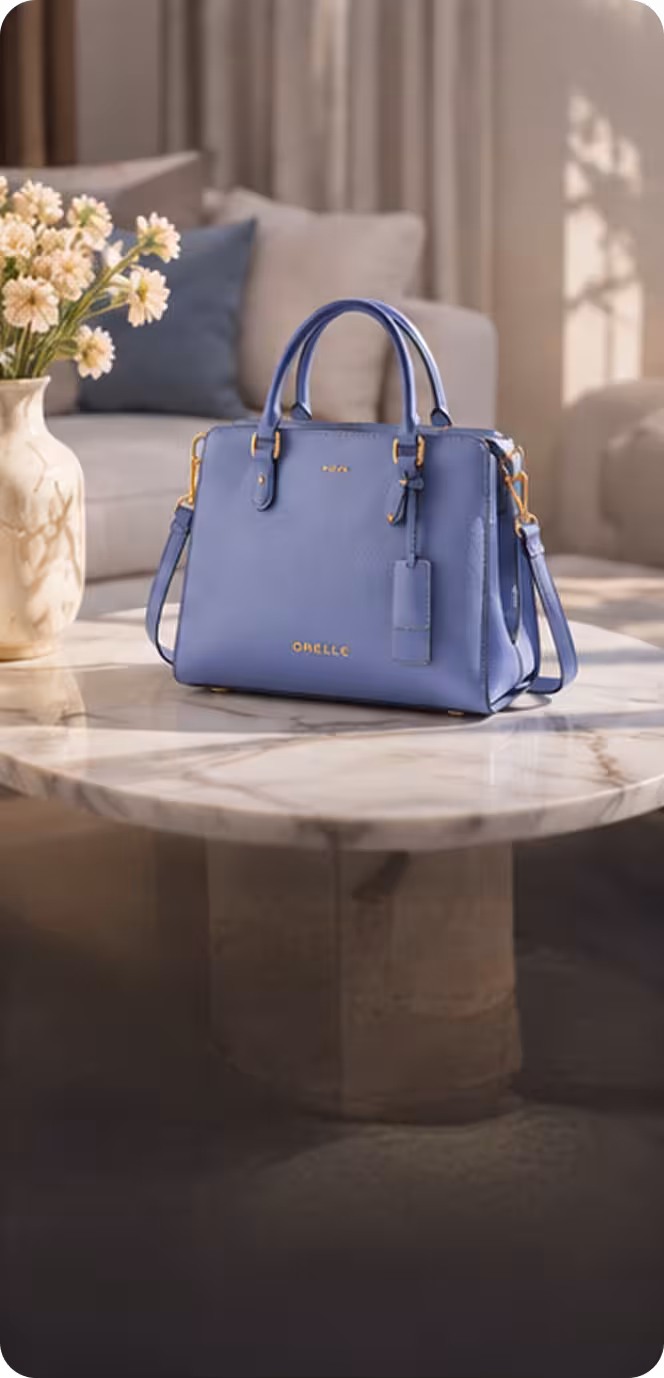 Blue leather handbag with handles and strap on a marble table in a living room setting.