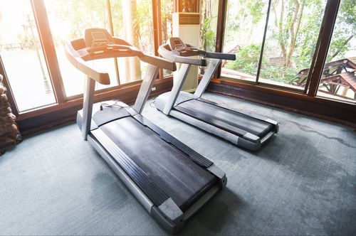 Assembling a treadmill in a home gym.