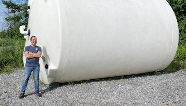 Horizontal rotomolded poly tank for industrial liquid storage, person shown for size reference